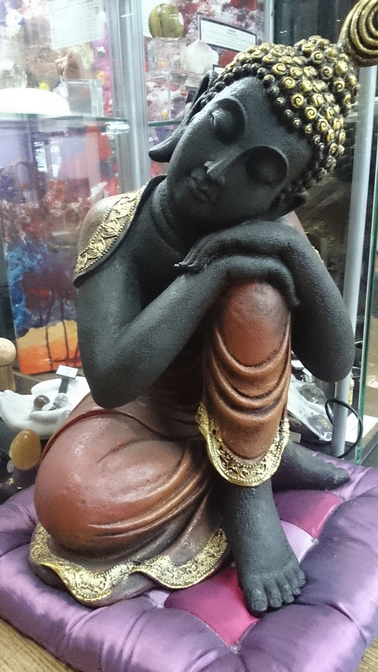 Resting Buddha sitting on purple cushion. Perfect for sacred spaces