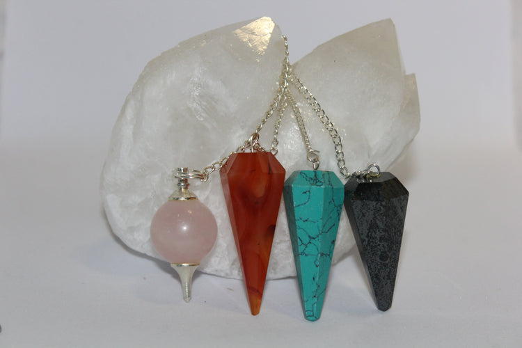 Pendulum display Rose Quartz, Carnelian, Blue Howlite and Hematite draped over large candle quartz points